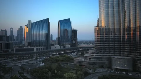 Reverse track back slow pan right at base of Burj Khalifa at 60m, sunset. Stock Footage 98953382