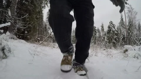 Reverse tracking shot of backpackers feet as he's walking in snow Stock Footage 145944999