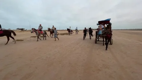 Reverse tracking shot of tourists enjoying horse caravan in desert Stockbeeldmateriaal 280689891