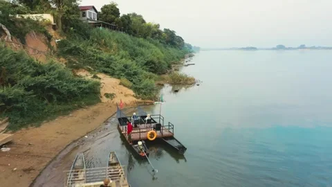 Reverse travelling above small Lao boat crossing Mekong river, Champassak, Laos. Stock Footage 246937797