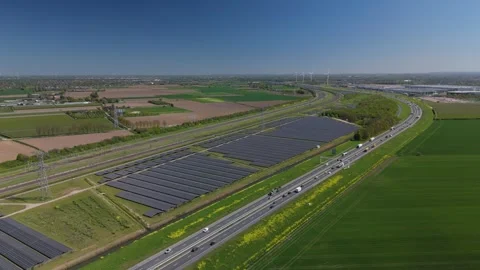 Reverse wide aerial view of solar farm beside Dutch transport corridor Vídeo Stock 333779920