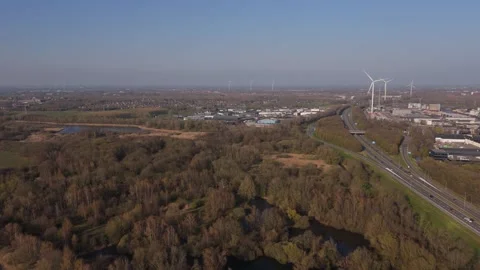 Reverse wide aerial view of wind turbines and industrial port Stock Footage 335651726