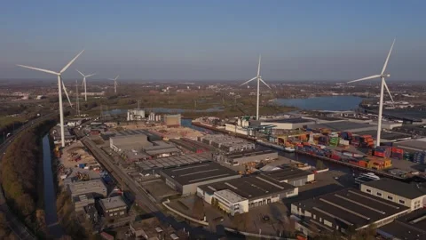 Reverse wide aerial view of wind turbines and industrial port Stock Footage 335658625