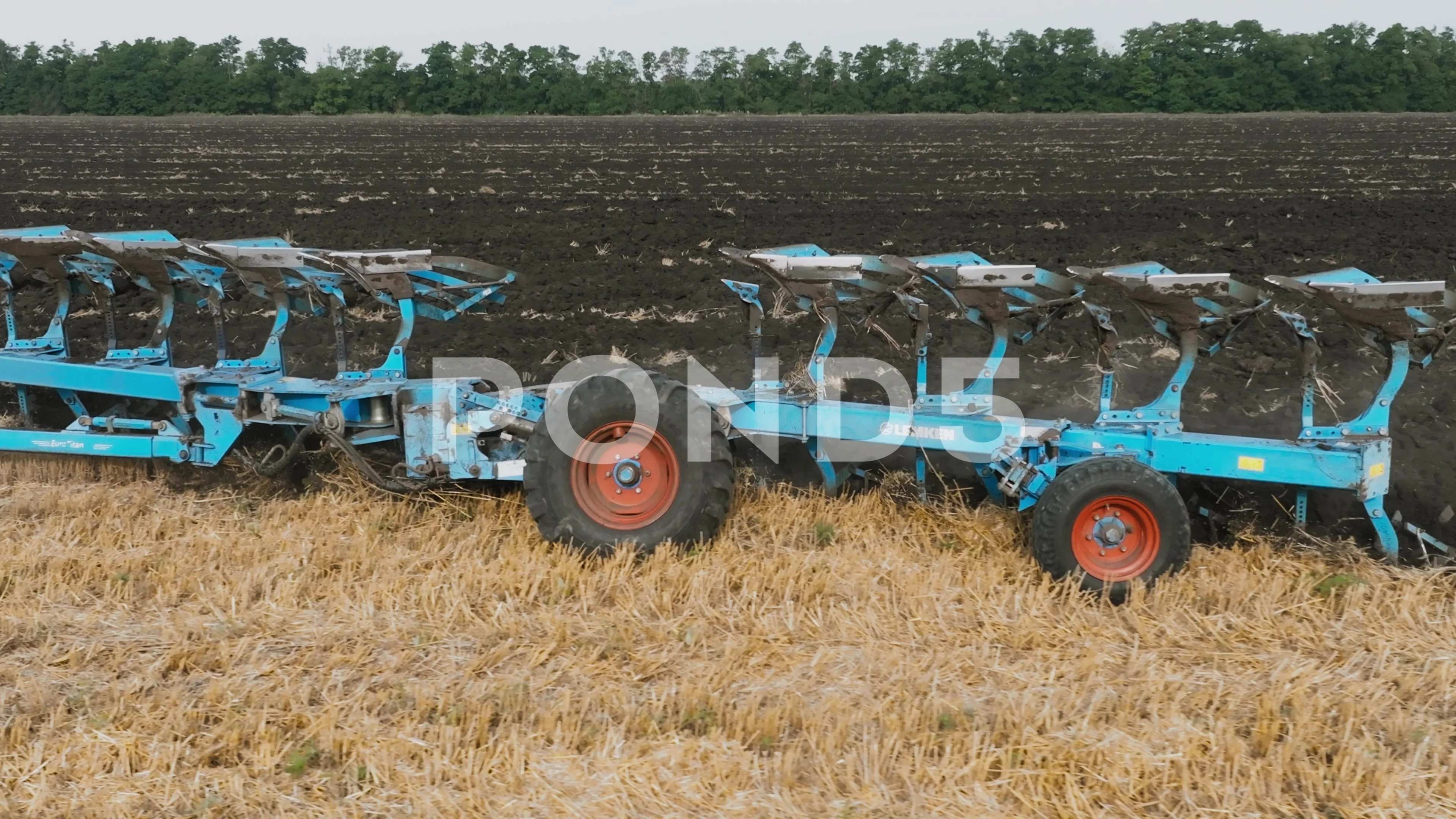 Reversible plow moving behind a tractor in an field. Hi productive reverse  plow