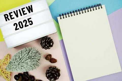 Review 2025 text in lightbox with notepad and Christmas tree and pine cone .. Stock Photos