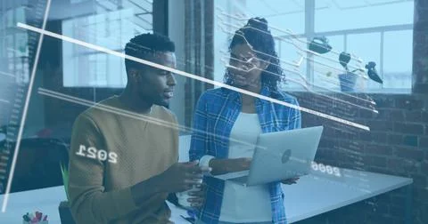 Reviewing code and data charts, two professionals working in tech office with Stock Photos