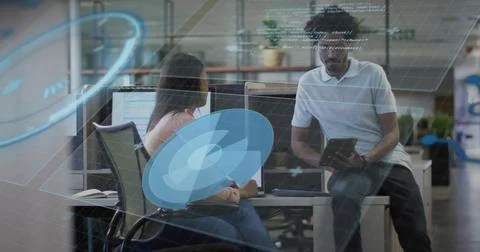 Reviewing code in office, team casually dressed holding tablet at dual monitors Stock Photos