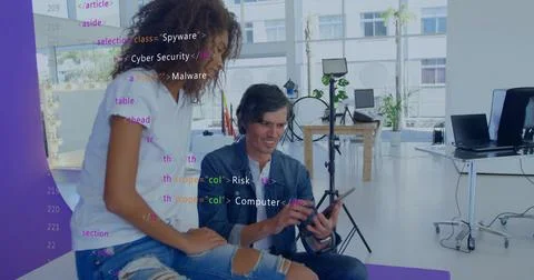 Reviewing code, two coworkers leaning, interacting with tablet in studio in Foto stock