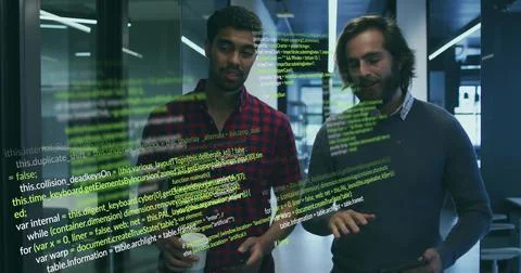 Reviewing code two developers wearing casual shirts using tablet in office with 库存照片