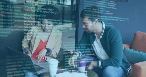 Reviewing code two engineers in blazers collaborating on laptop in office lounge Stock Photos