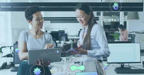 Reviewing code two women collaborating at desk in open-plan tech office, with Stock Photos
