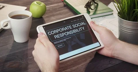 Reviewing corporate social responsibility internet page using digital tablet at Stock Footage