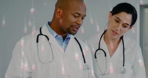 Reviewing data doctors wearing lab coats and stethoscopes in medical office, Stock Photos