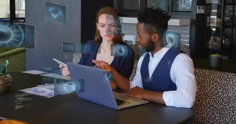 Reviewing data two business professionals pointing at laptop and tablet in Stockfoto's