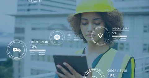 Reviewing engineer reading tablet on building site, with yellow safety helmet, Fotos de archivo