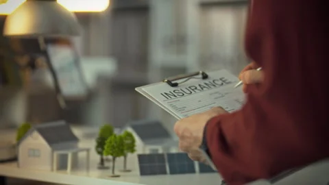 Reviewing an insurance form while planning a sustainable housing project Stock Footage 331287741