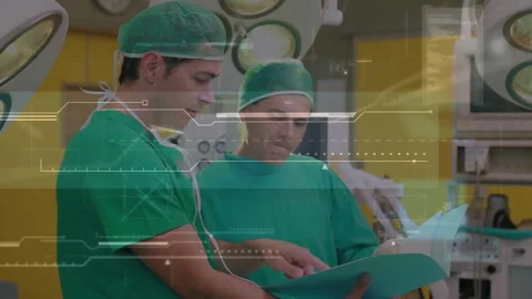 Reviewing patient chart, two surgeons in operating suite with AR metrics Stock Footage 314148284