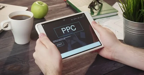 Reviewing PPC info using digital tablet at desk Stockbeeldmateriaal 80736216