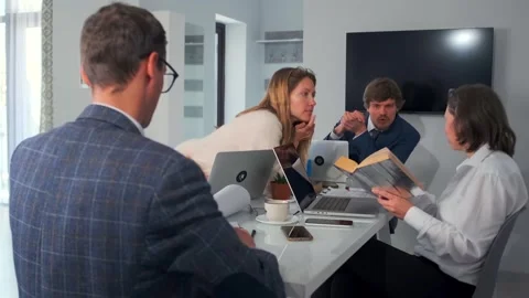 Reviewing reports and spreadsheets carefully, financial experts analyze printed Stock Footage 319566296