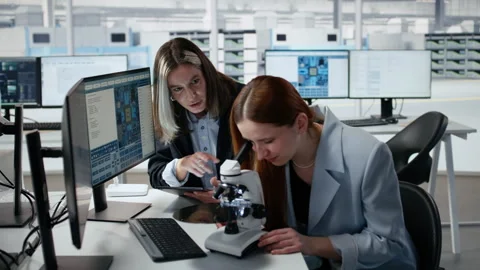 Reviewing semiconductor substrate structures, microscope and woman in office Stock Footage 335881160