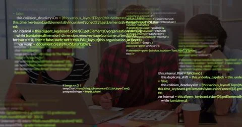 Reviewing software developers collaborating on code in meeting room, with laptop 库存照片