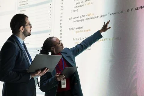 Reviewing source code, laptop and engineering team using digital display 스톡 사진