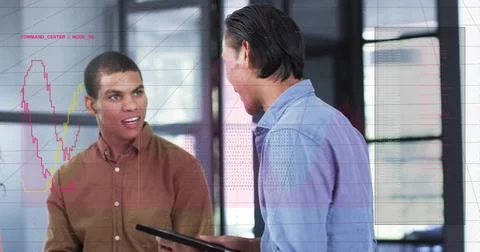 Reviewing tablet data two men in brown, light-blue shirts discussing in office Stock Photos