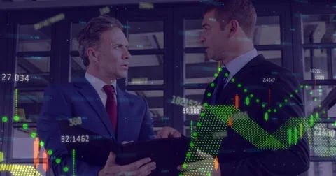 Reviewing two men in suits using digital tablet in server room, with hologram Stockfoto's