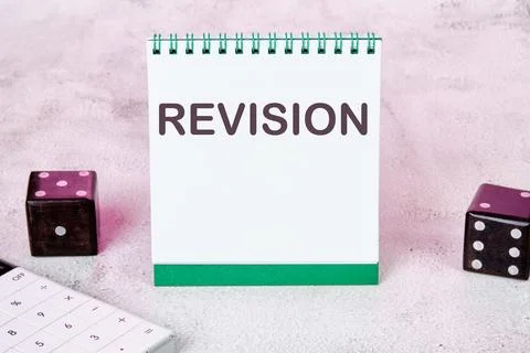REVISION text on a white notepad sheet next to dice on an abstract background Stock Illustration