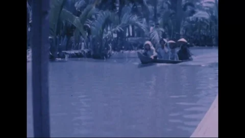 Revolutionary Development team pass native boats along narrow canal - 1969 Video stock 96143237