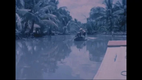 Revolutionary Development team pass native boats along narrow canal - 1969 Video stock 96143238