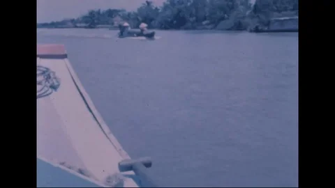Revolutionary Development team pass native boats along narrow canal - 1969 Video stock 96143243