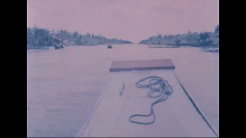 Revolutionary Development team pass native boats along narrow canal - 1969 Video stock 96143249