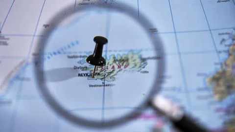 Reykjavik marked on a printed map, using a magnifying glass. Stock Photos
