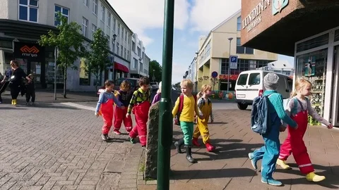 Reykjavik school kids walking across street Stock Footage