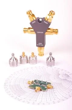 RF mixer electronics PCB in front of Smith chart and other microwave measurem Foto stock
