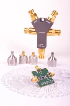RF mixer electronics PCB in front of Smith chart and other microwave measurem Stock Photos