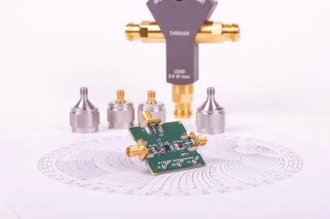 RF mixer electronics PCB in front of Smith chart and other microwave measurem Stock Photos