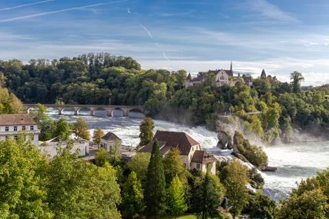 Rheinfall the large waterfall surround with green forest and blue sky backgro Stock Photos