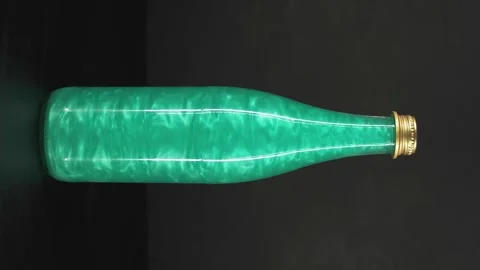 Rheoscopic liquid inside glass bottle on black background. Green. Vertical video Stock Footage 252032981