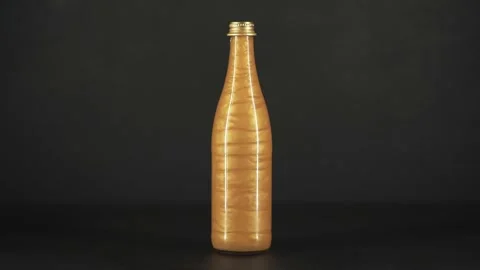 Rheoscopic liquid inside glass bottle on black background. Gold. Stock-Footage 252033021