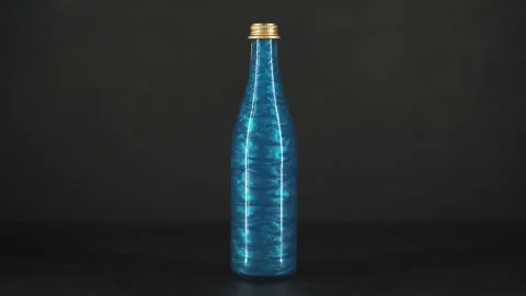 Rheoscopic liquid inside glass bottle on black background. Blue. Video stock 252033101