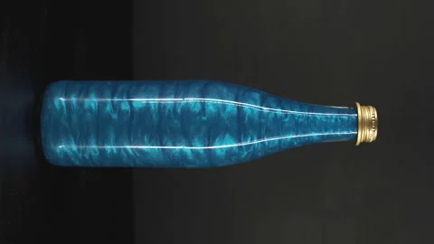 Rheoscopic liquid inside glass bottle on black background. Blue. Vertical video Video stock 252033620
