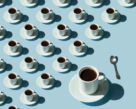 Rhythmic pattern from cups with coffee on a blue background. Foto stock