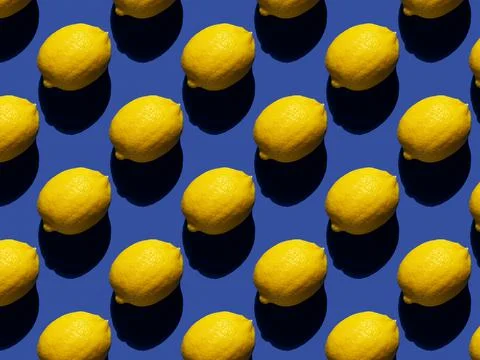 Rhythmic pattern of lemons on a blue background. Hard shadows. Foto stock
