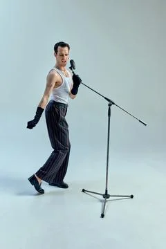 Rhythmic tension embodied in angular stance, artist fully immersed in musical Stock Photos