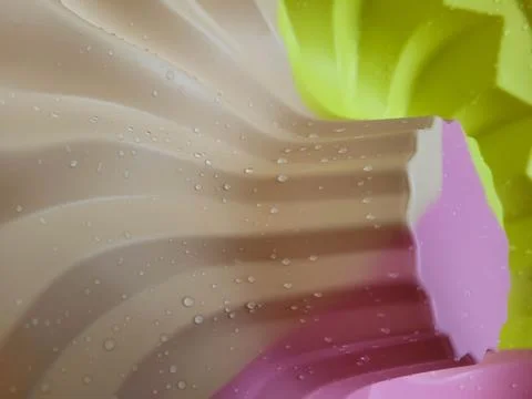 A ribbed background made of multicolored silicone baking molds with water Stock Photos