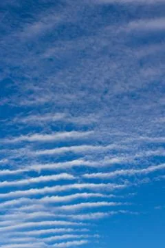 Ribbed clouds on a blue sky background Stock Photos