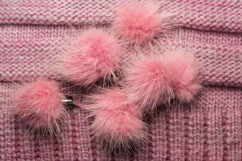 Ribbed knit wool like texture with fur pompoms, textured knitted fabric knitt Stock Photos