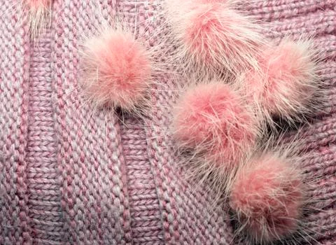 Ribbed knit wool like texture with fur pompoms, textured knitted fabric knitt Stock Photos